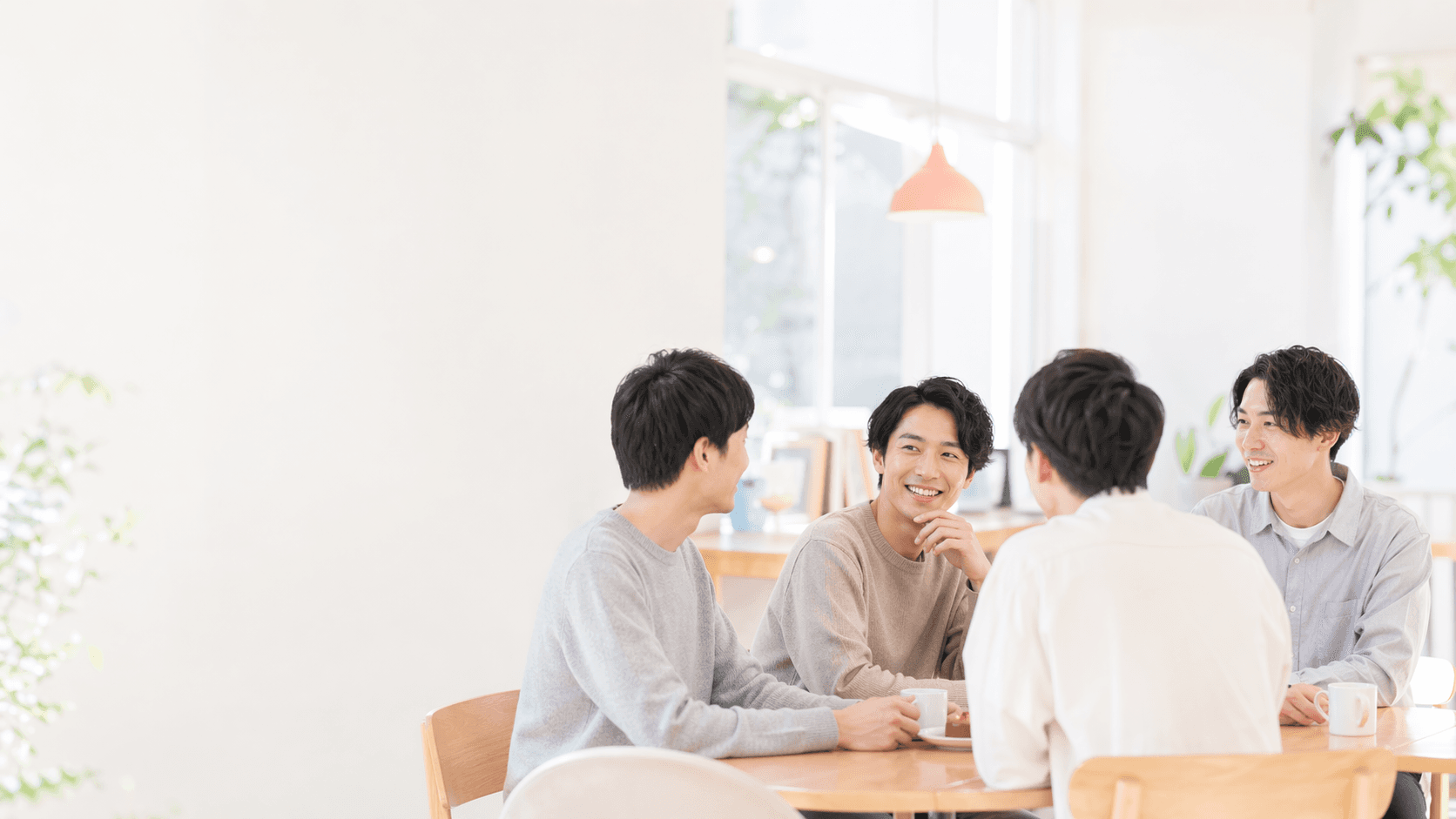 明るいカフェで4人が自然に会話している G-Conne のヒーロー画像